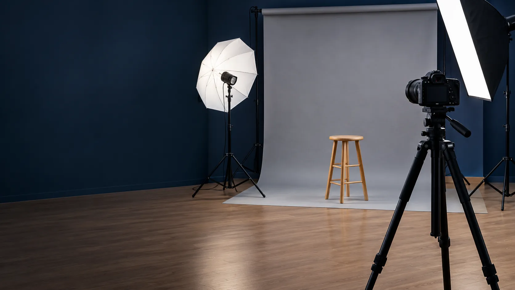 Studio photo avec appareil sur trépied, fond gris clair, parapluie et boîte à lumière (illustration)
